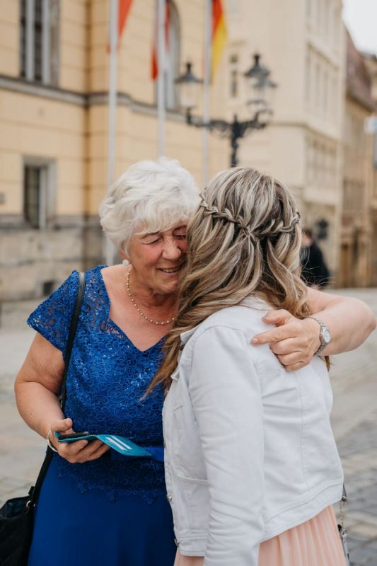 Die Braut begrüßt eine ältere Angehörige bei ihrer Hochzeit