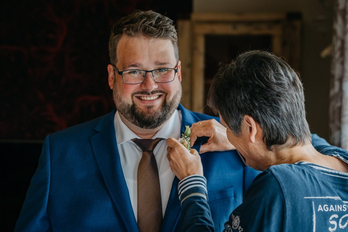 Tobias bekommt beim Getting Ready seinen Anstecker befestigt