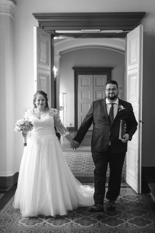 Janina und Tobias gehen Hand in Hand durch den Flur des Rathauses