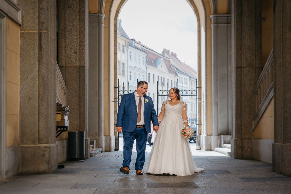 Janina und Tobias gehen durch die Arkaden des Zittauer Rathauses