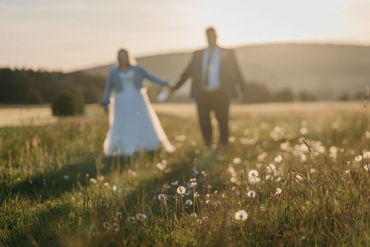 Janina und Tobias halten sich im Abendlicht an den Händen