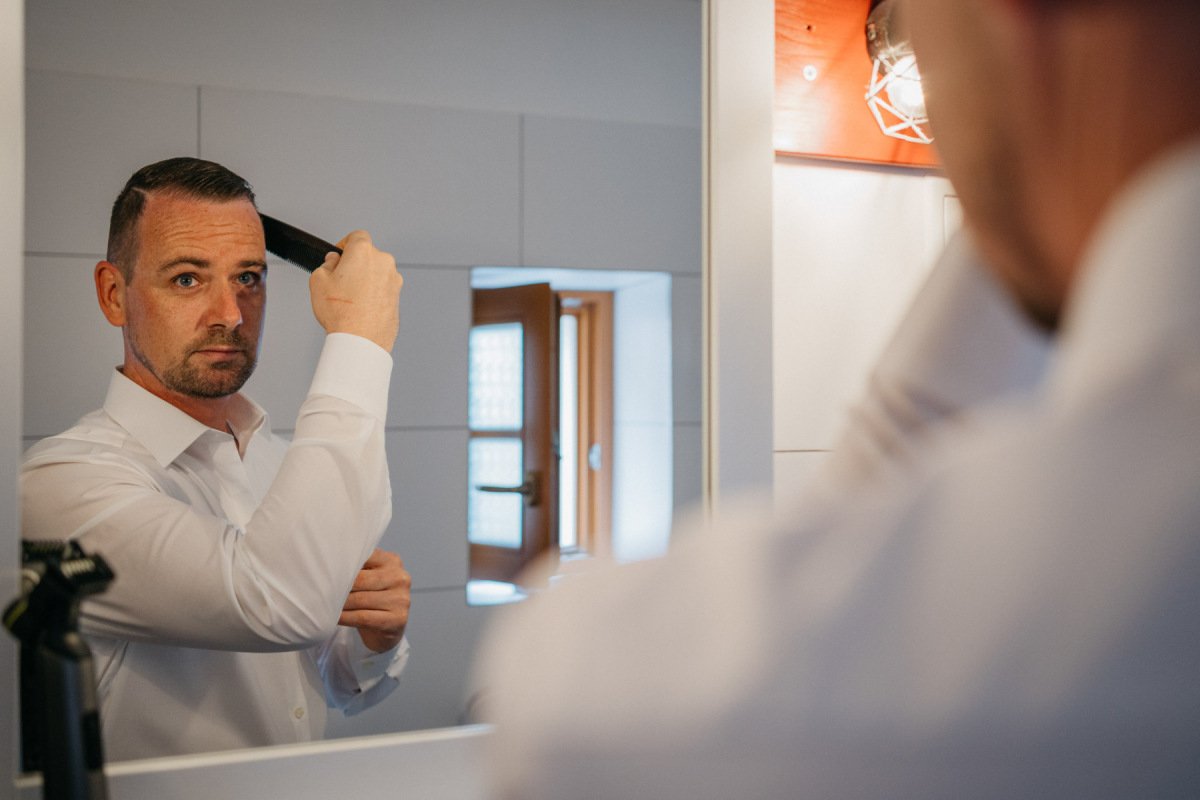 Robert richtet sich vor dem Spiegel für die Hochzeit her