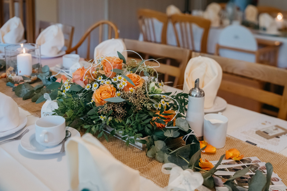 Hochzeitstafel mit orangefarbener Dekoration in der Beckenbergbaude