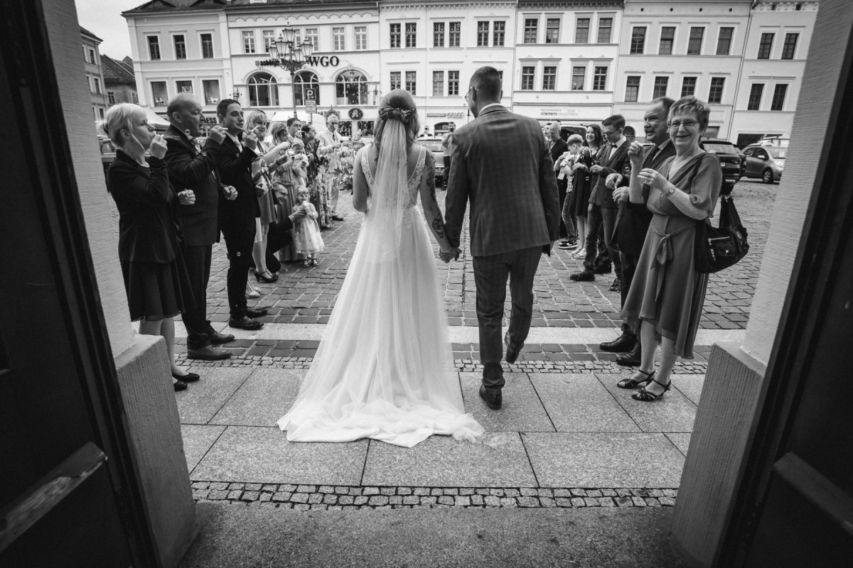Linda und Robert verlassen das Standesamt durch das Spalier