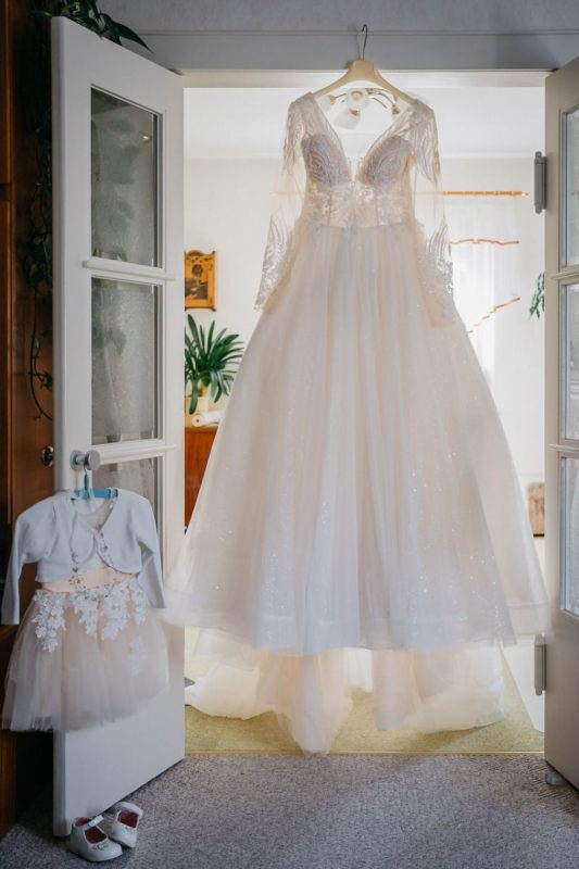 Detailaufnahme von Brautkleid und Hochzeitsschuhen