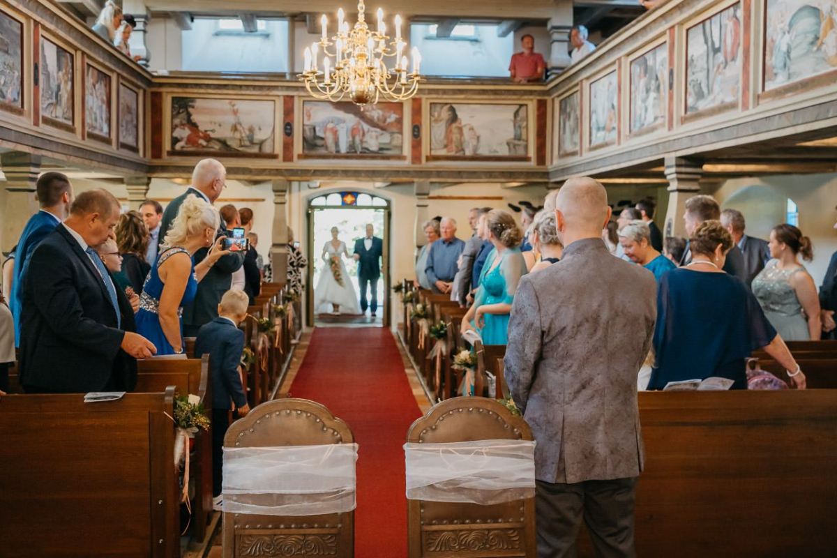 Braut und Bräutigam stehen im Kirchenportal