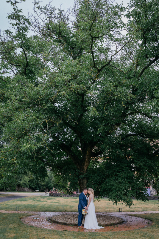 Sandra und Andy stehen beim Paarshooting unter einem großen Baum