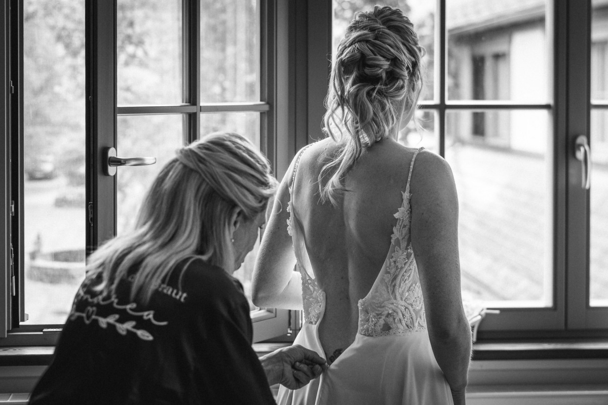 Sandras Hochzeitskleid wird beim Getting Ready geschlossen