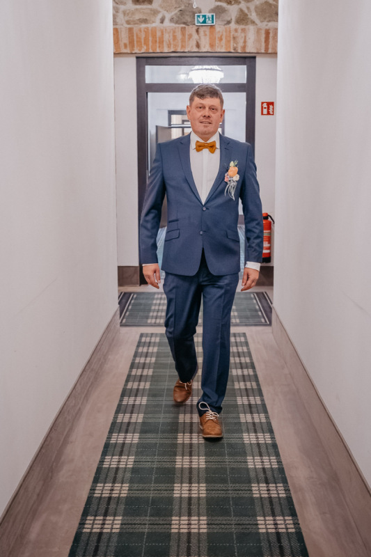 Andy geht fertig angezogen durch den Flur