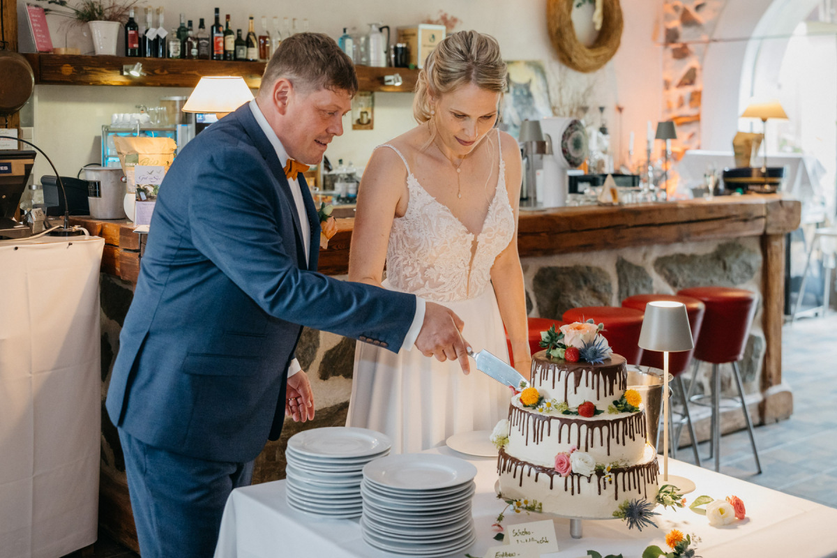 Sandra und Andy schneiden gemeinsam ihre Hochzeitstorte an
