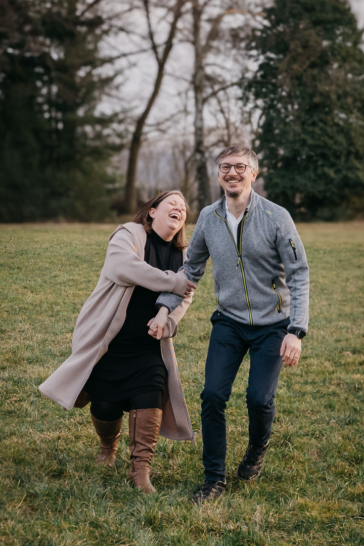 Jens und Nora Schaffhirt lachen gemeinsam bei einem Spaziergang im Grünen